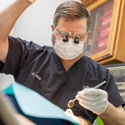Doctor Mulkey examining a patient with dental implants in Weatherford