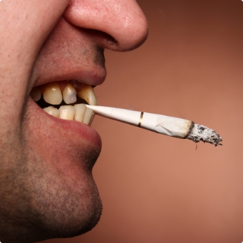Close up of person holding cigarette between their teeth