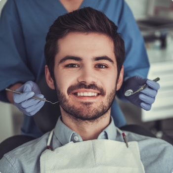 Young man with short beard in dental chair