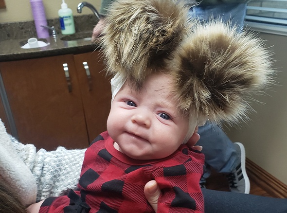 Baby with poofy hat in dental office