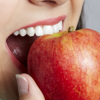 Close up of person biting into a red apple