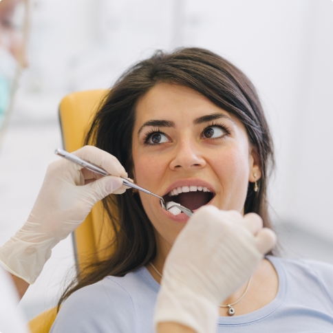 Woman having her mouth examined by dentist during preventive dentistry checkup