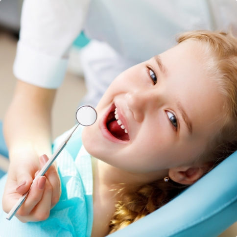 Young child grinning in dental chair
