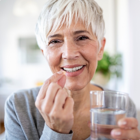 Woman with pill and glass of water for oral conscious sedation dentistry in Weatherford
