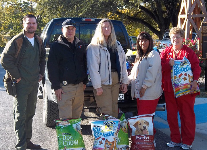 Dental team members with pet supplies in front of pickup truck