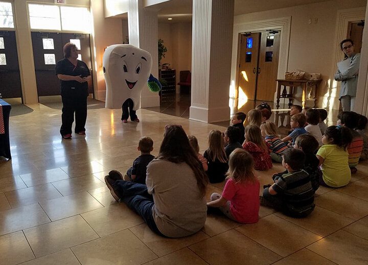 Group of kids watching tooth mascot give a presentation