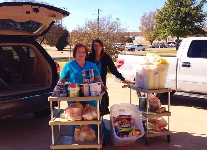 Two dental team members transporting donated food