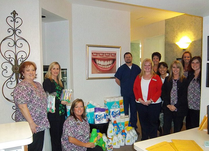 Dental team with donated cleaning supplies and toiletries