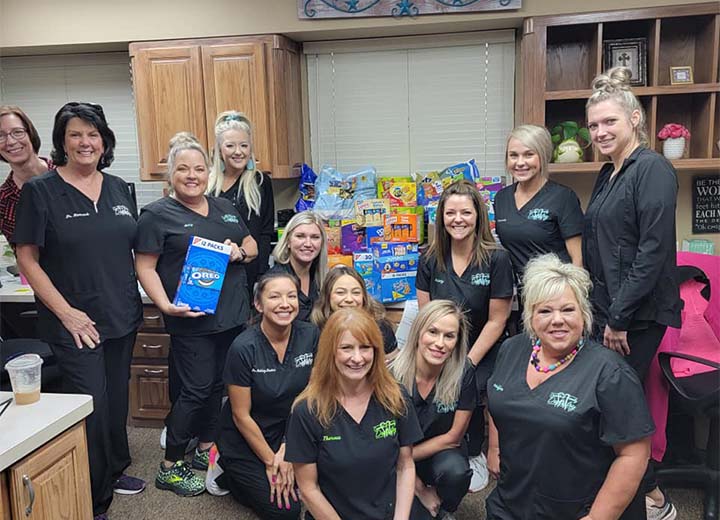 Dental team posing with snack foods to be donated