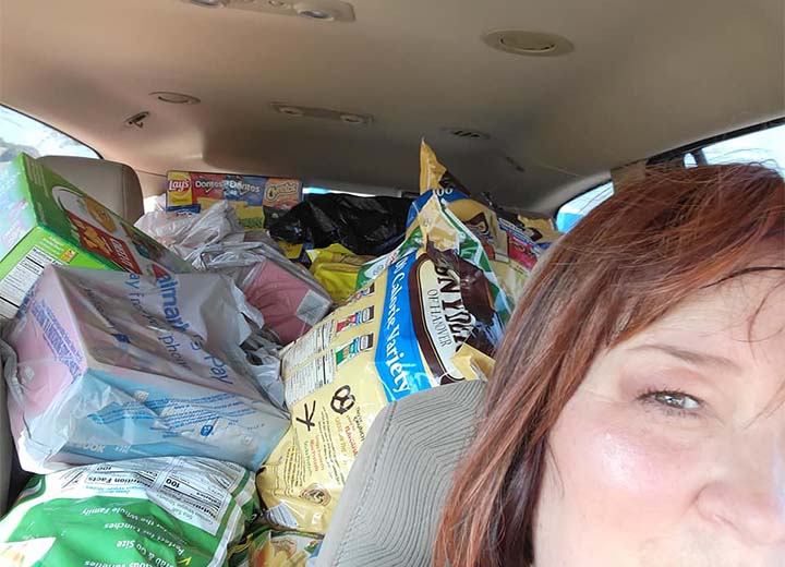 Dental team member in front seat of car with entire back of car filled with items to be donated