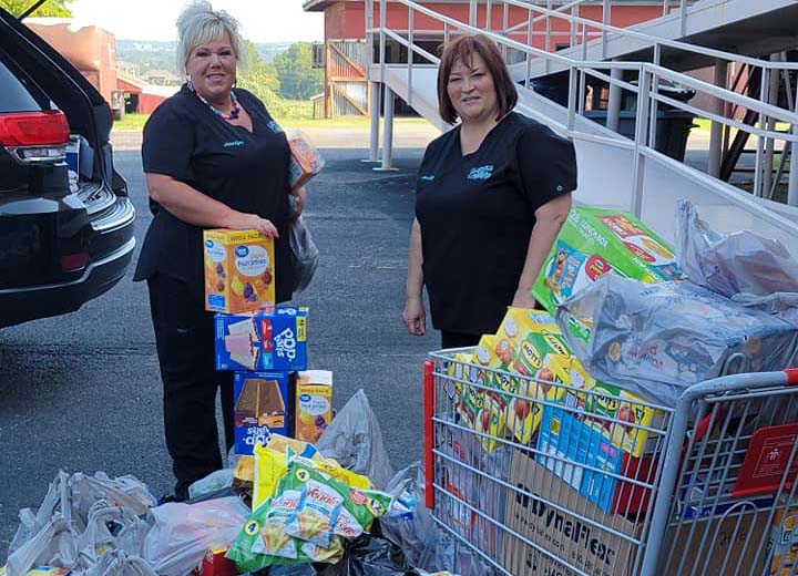 Dental team members with shopping carts full of food items to be donated