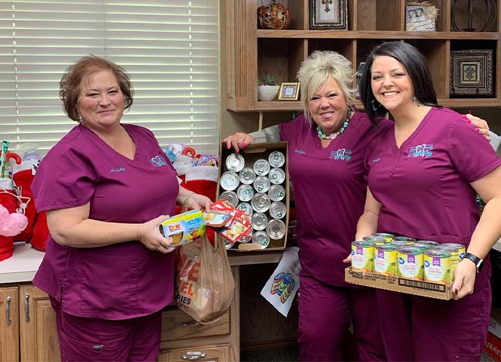 Three dental team members at canned food drive