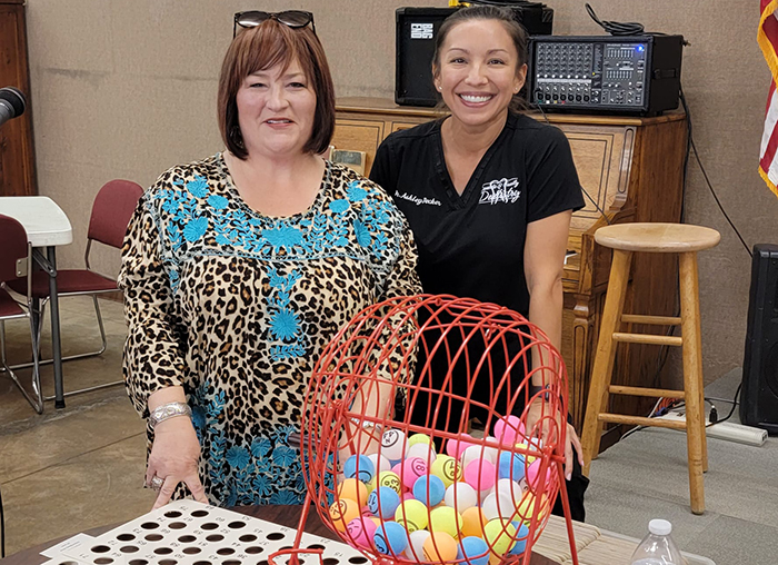 Two Weatherford dental team members with bingo ball cage