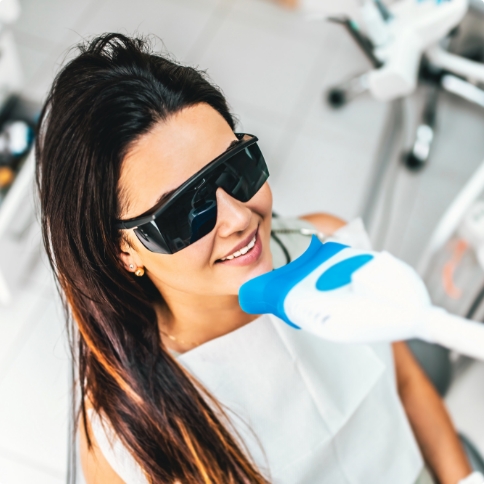 Woman getting professional teeth whitening in dental office