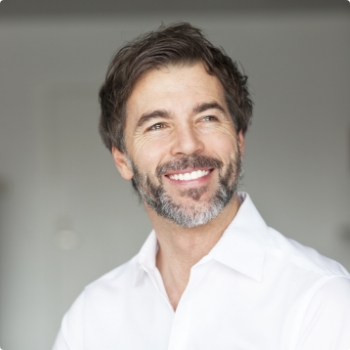 Man with beard and white collared shirt smiling