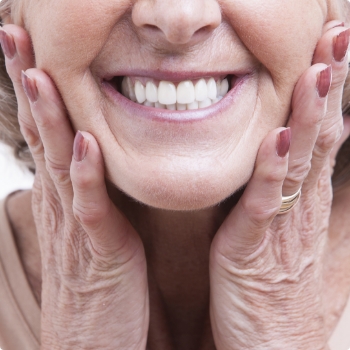 Close up of smiling senior woman touching her face