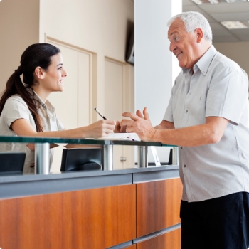 Senior man talking to dental office receptionist