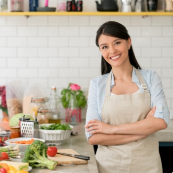 Woman in her kitchen chopping vegetables