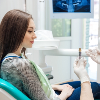 Dentist showing a dental implant to a patient