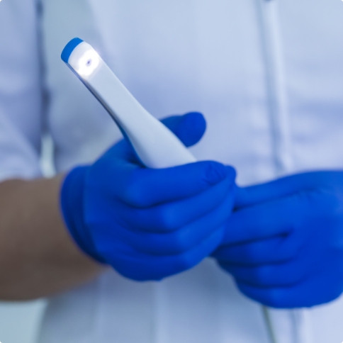 Dentist holding thin white intraoral camera