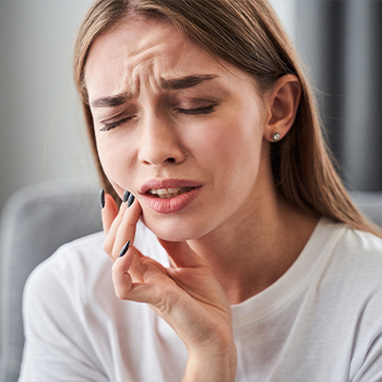 Woman holding her cheek in pain