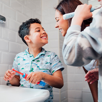 Mother and young son brushing their teeth together