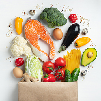 Several fruits and vegetables in a grocery bag