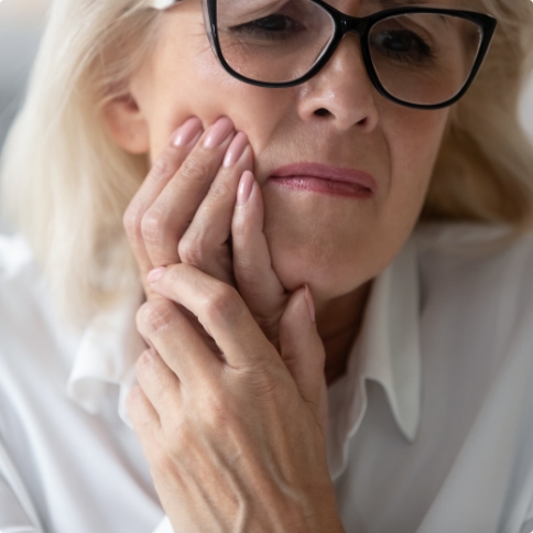 Woman holding her cheek in pain