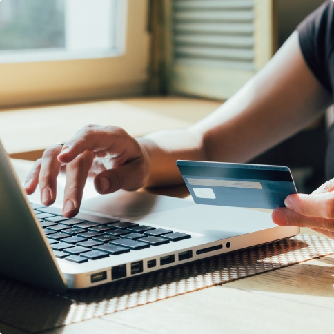 Person typing their credit card information on laptop