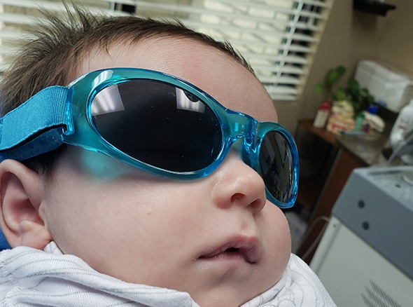 Baby wearing sunglasses in dental treatment room