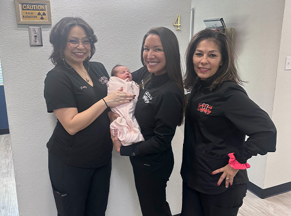 Dr. Decker holding baby with other team members