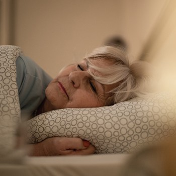 A woman resting after dental implant surgery