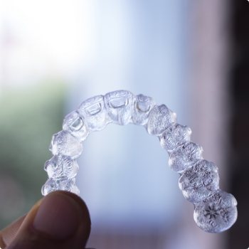 Hand holding an Invisalign tray