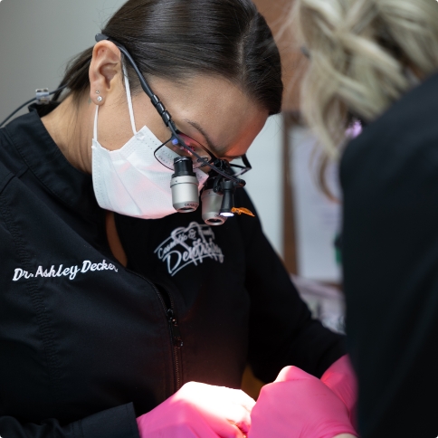 Doctor Decker wearing dental binoculars while treating a patient