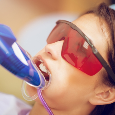 Young girl in dental chair with fluoride trays over her teeth