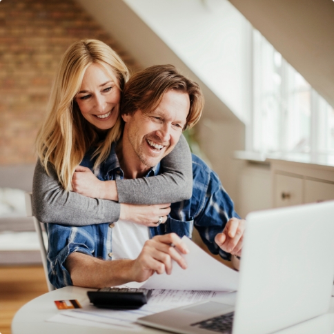 Man and woman looking at laptop for dentist reviews in Weatherford