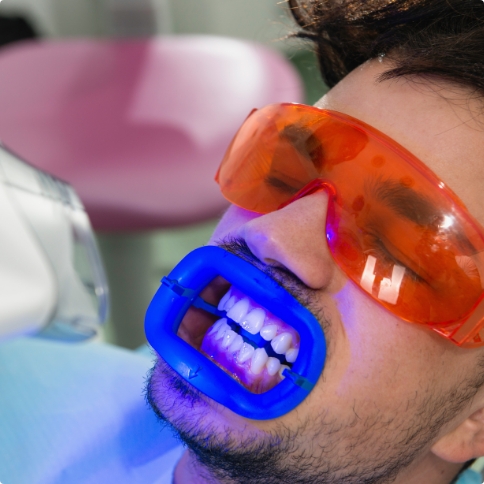 Man getting professional teeth whitening in dental office