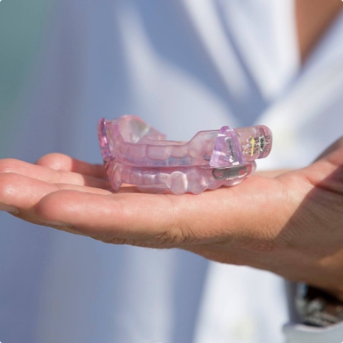 Dentist holding light purple intraoral appliance