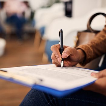 Woman filling out form on blue clipboard