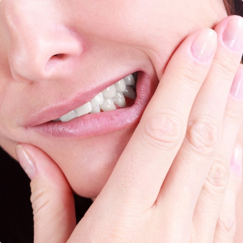 Person holding their cheek in pain before tooth extractions in Weatherford