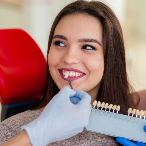 Young woman in dental chair trying on dental veneers in Weatherford