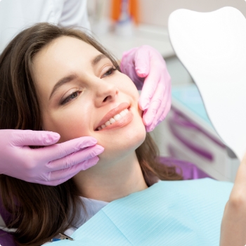 Dental patient admiring her smile in mirror