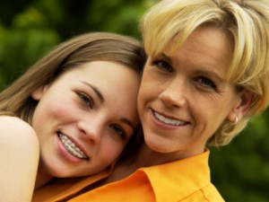 daughter wearing braces hugging her mother