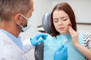 a woman in pain visiting an emergency dentist