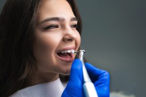 Dentist cleaning a female patient’s teeth