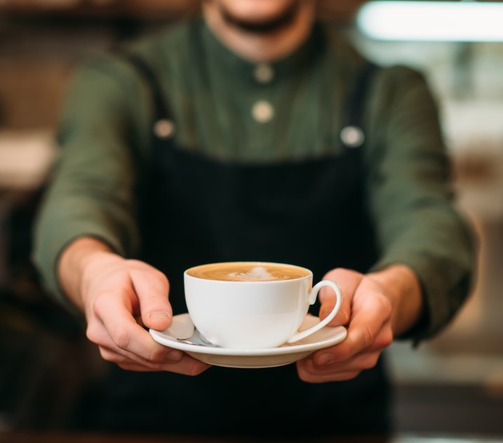 Barista holding coffee out
