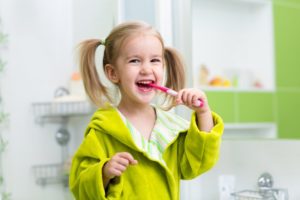 girl smiling brushing her teeth